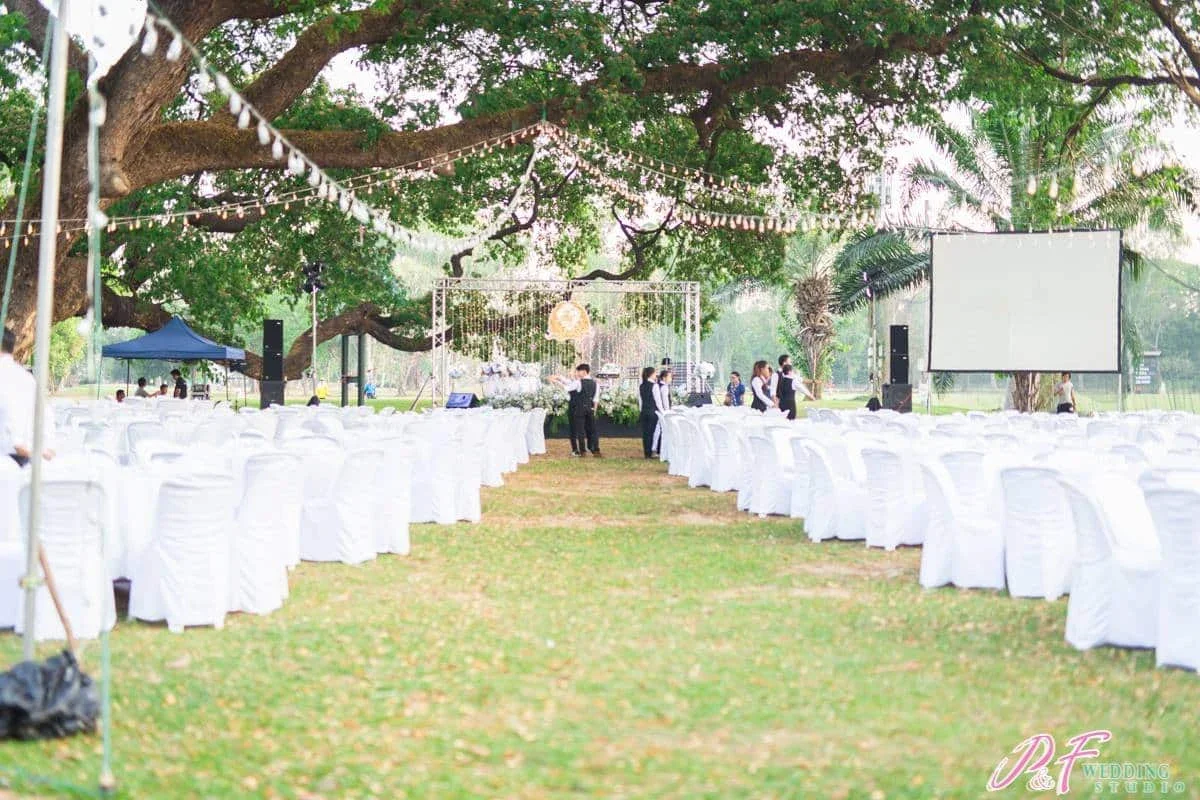 Outdoor wedding aisle with white chairs at Chiang Mai Gymkhana Club